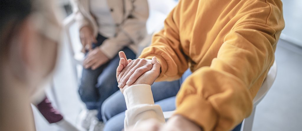 Two people in therapy holding hands