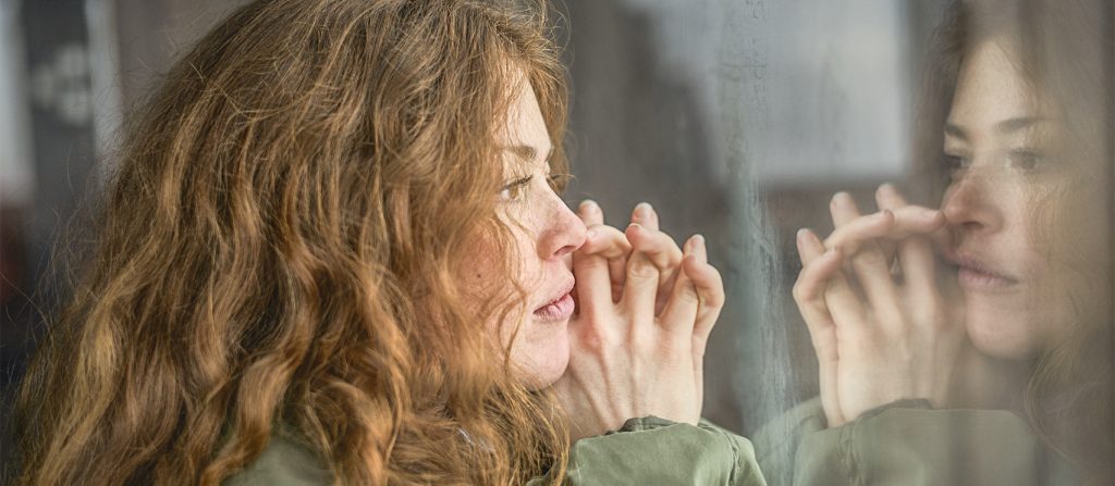 Woman in through staring out a window