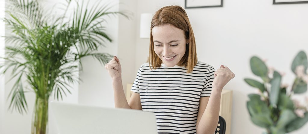 Woman excitedly looking at a computer screen
